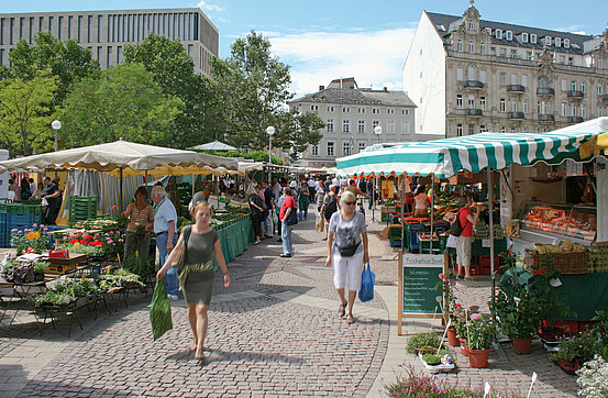 View of Wiesbaden farmers market with stalls and shoppers on a sunny day